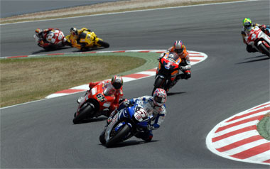 Colin Edwards about to get swamped by Loris Capirossi. Nicky Hayden can only look on...