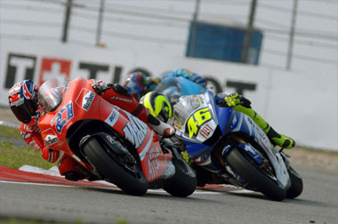 Rossi tries to get onto the same bit of tarmac as Stoner while Hopkins hangs back to pick up the bits if it goes wrong.
